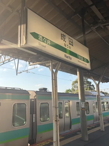 電車と駅名標、午後の陽射し