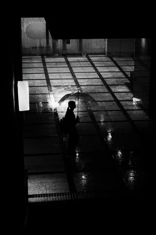 雨粒に映る街灯、一人佇む影
