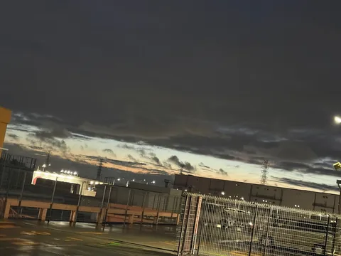 夕暮れの高架下、電気塔と倉庫街