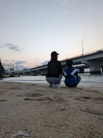 水辺に佇む、橋を見上げる二人