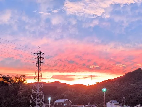 夕焼けの電線と丘の影
