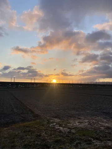 夕日と電車の線路、耕された大地