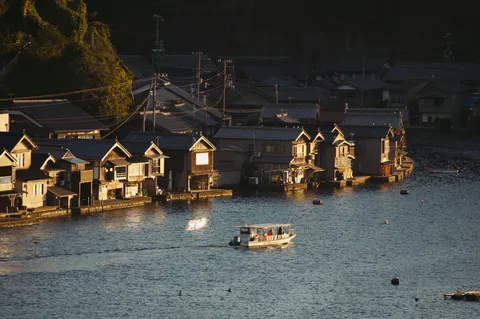 夕暮れ時の漁村、水面に映る灯り