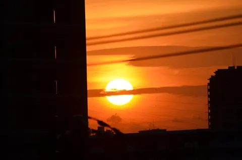 ビル街に沈む燃える太陽