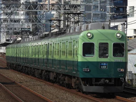 緑の電車、都会を行く