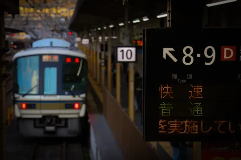 駅の案内板と電車、旅の始まり