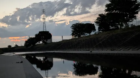 静寂の川面に映る灯りと雲