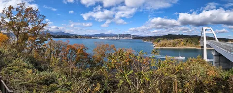 秋色を映す海と白い橋