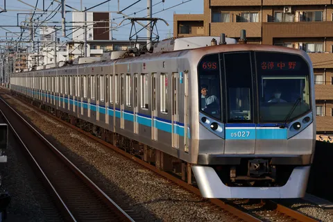 光を浴びて進む都市の電車