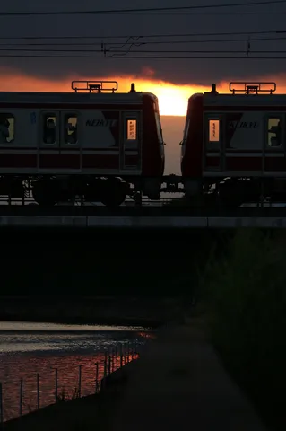 夕暮れの鉄路、水面の反射