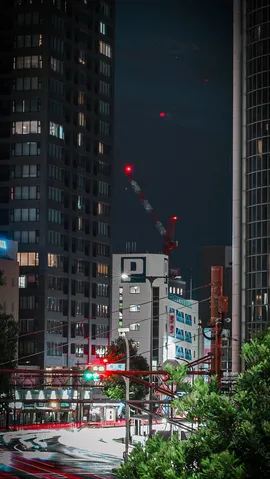 夜の高層と赤い光跡