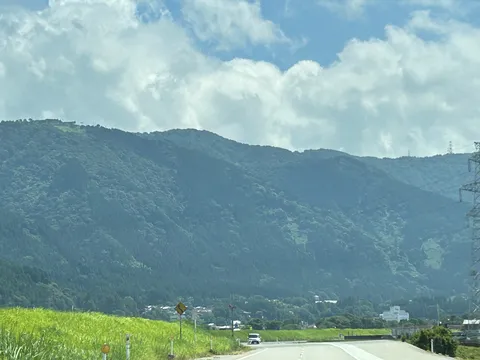 雲湧く夏の山並みと道